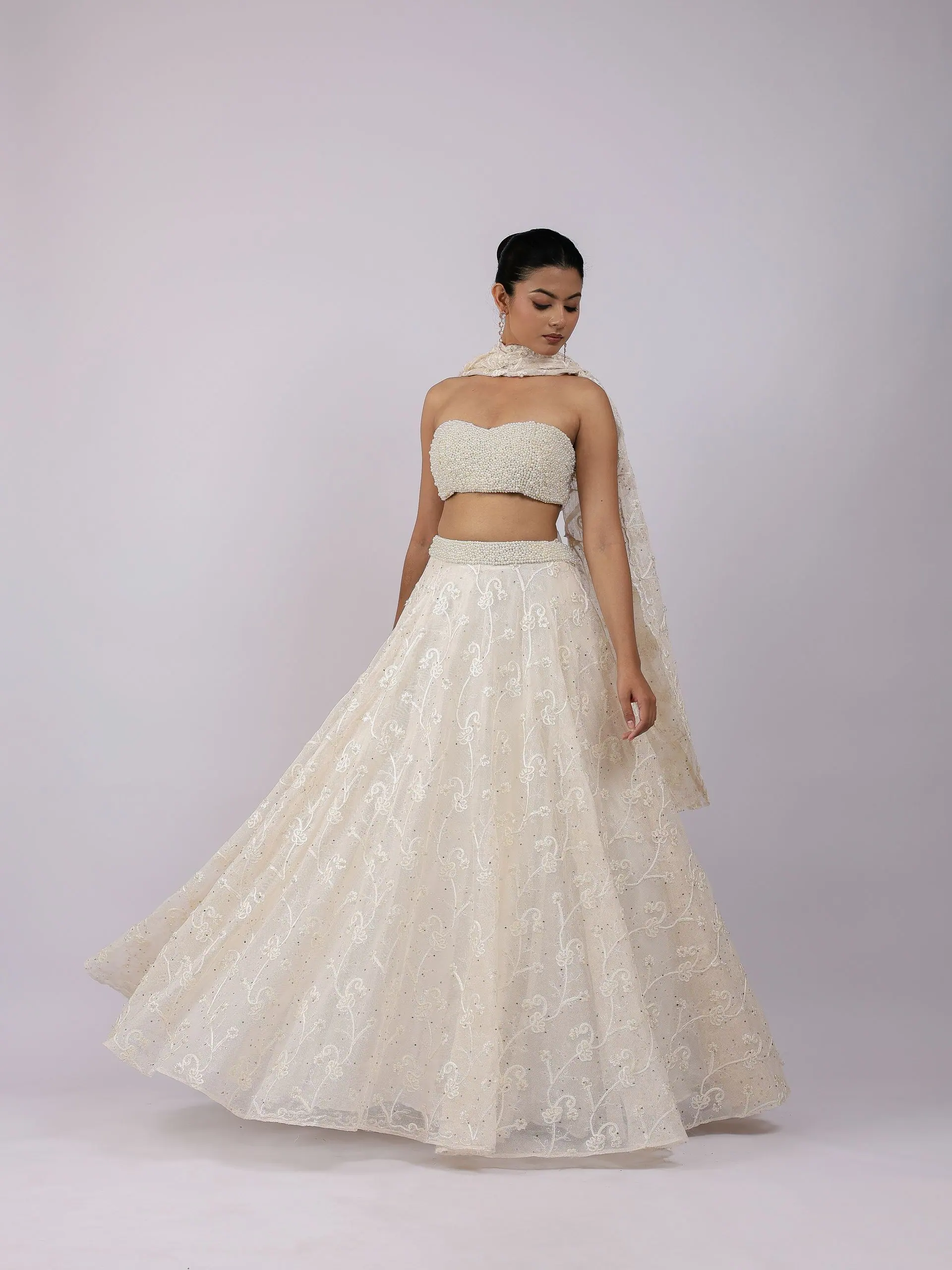 Ivory lehenga with a pearl bustier and embroidered dupatta, full length