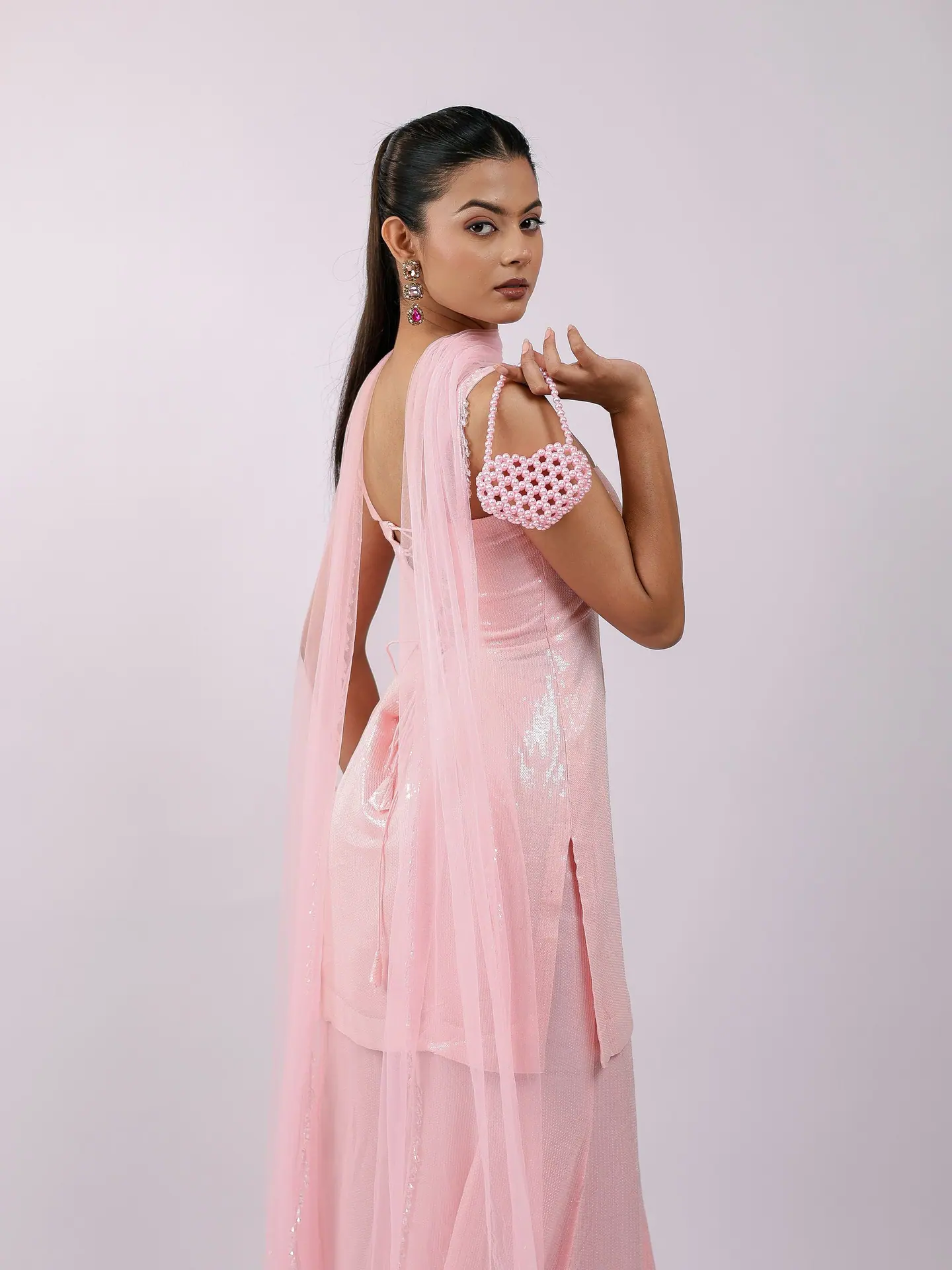 Blush sharara set with a pearl heart bag, over-the-shoulder pose